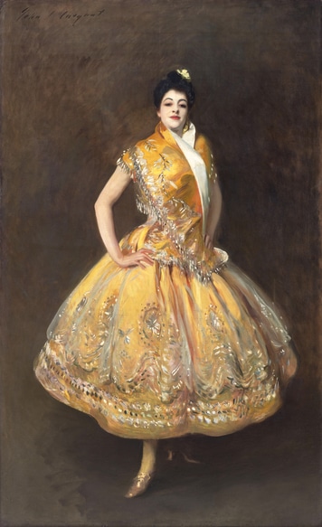 A painting of a young women with her hands on her hips standing in a confident pose. She wears an opulent yellow dress and looks directly at the viewer.