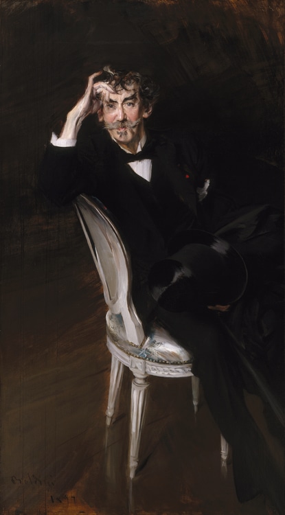 A painting of James McNeill Whistler sitting cross-legged, leaning over the back of a white chair in what might be an empty ballroom. He wears a black suit and holds a top hat on his lap.